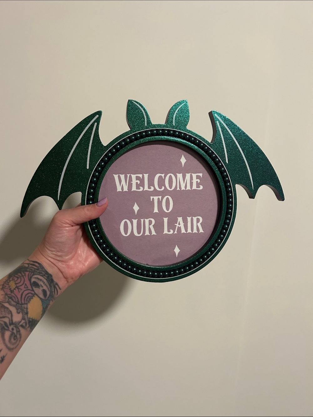 Decorative "Welcome to Our Lair" Bat Wall Sign in Green and Mauve